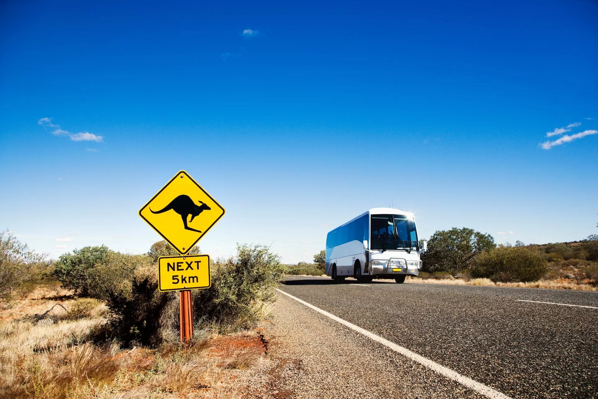 A bus in rural Australia with a kangaroo crossing sign