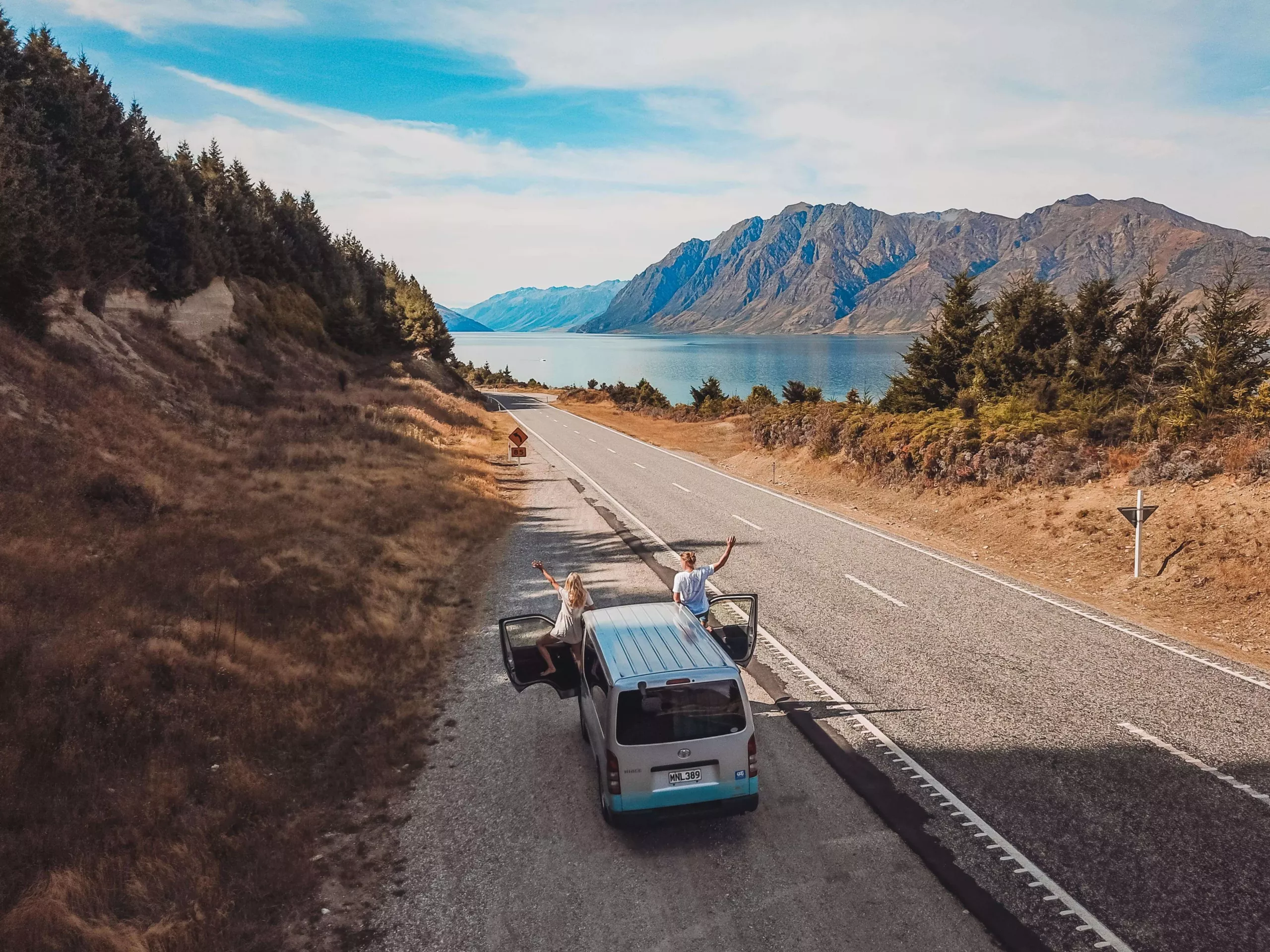 Hi Top Campervan touring new zealand. Two travellers on an open road.