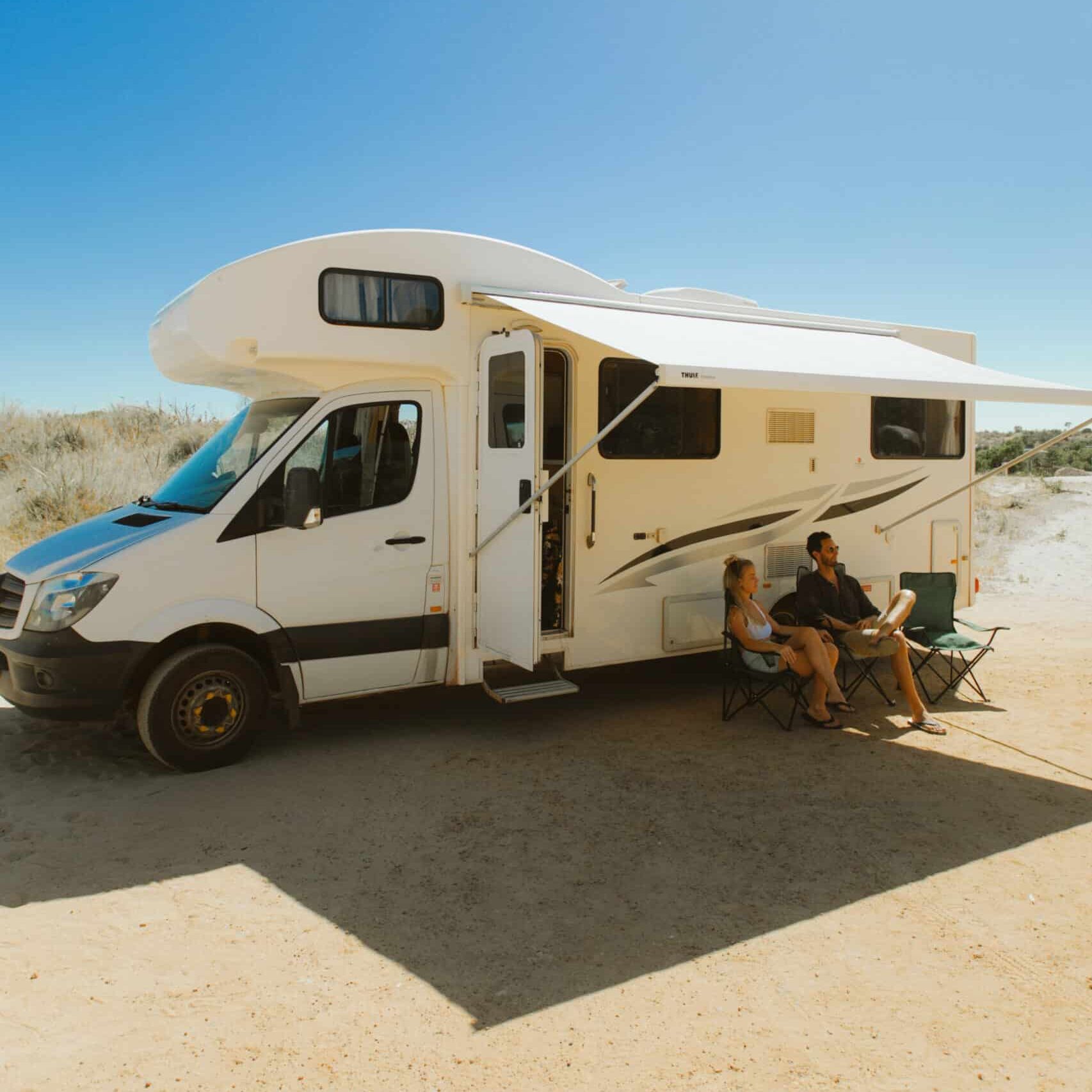 Campervan with chairs outside under shade