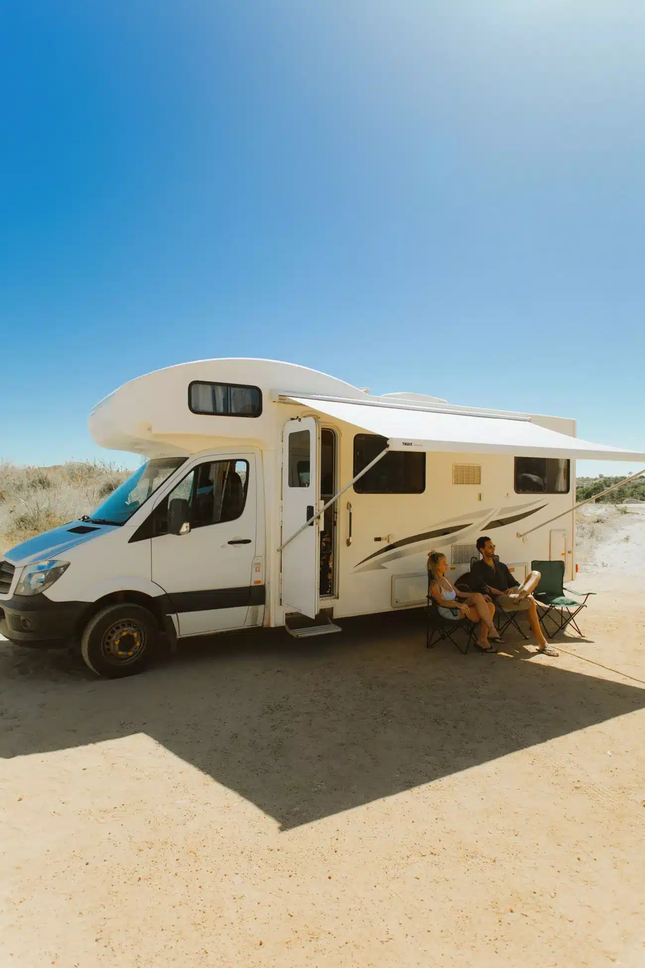 Campervan with chairs outside under shade