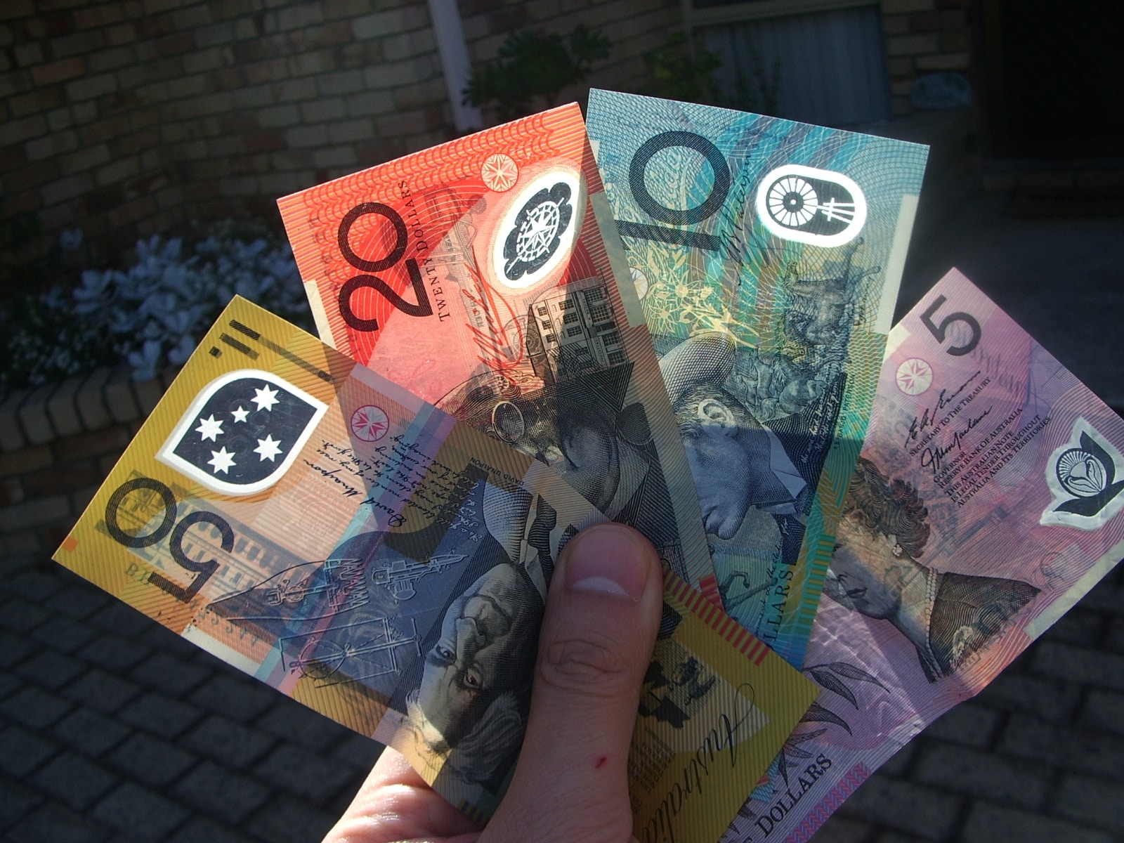 A fan of Australian Dollars in someone's hand