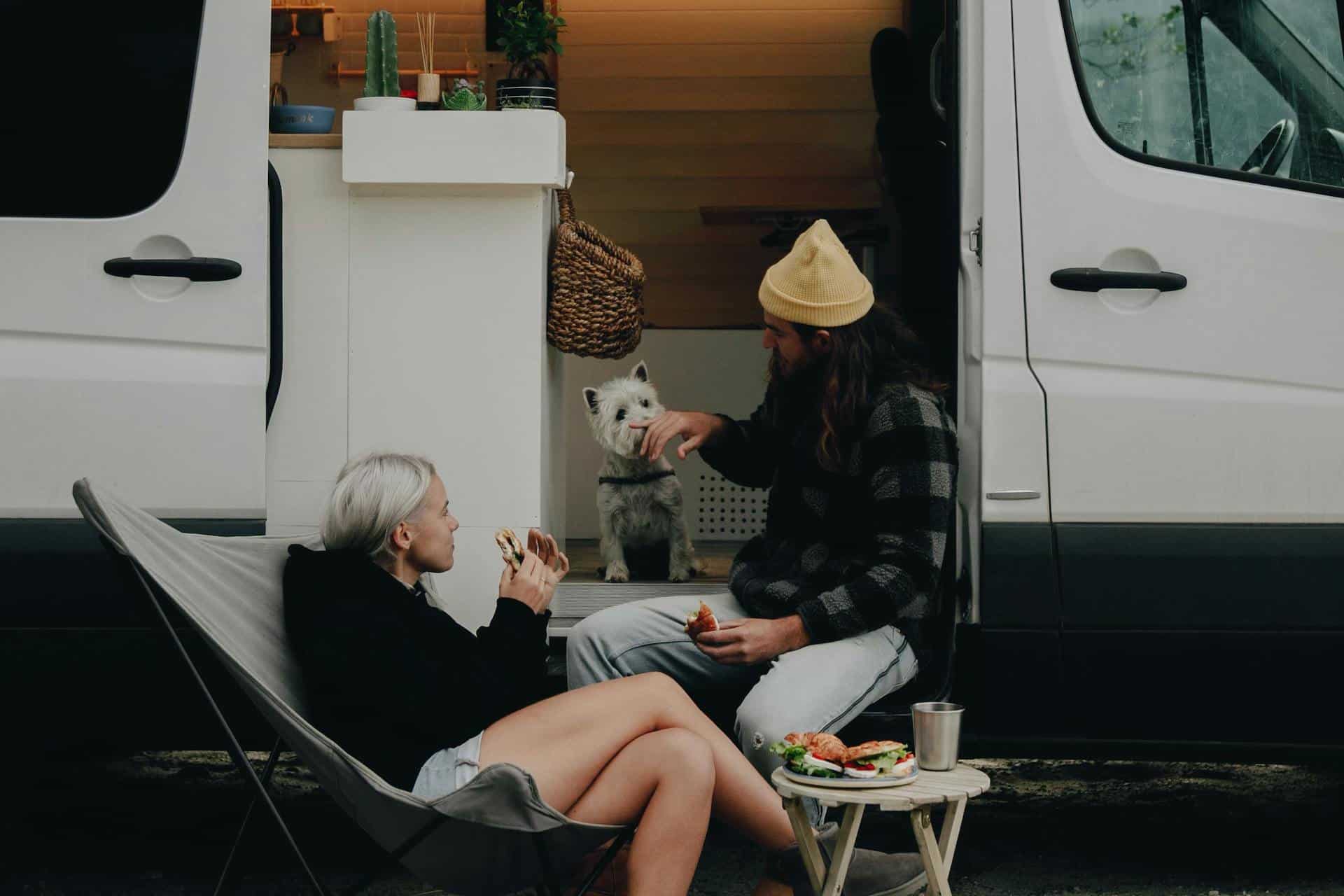 Two people with their dog in a campervan