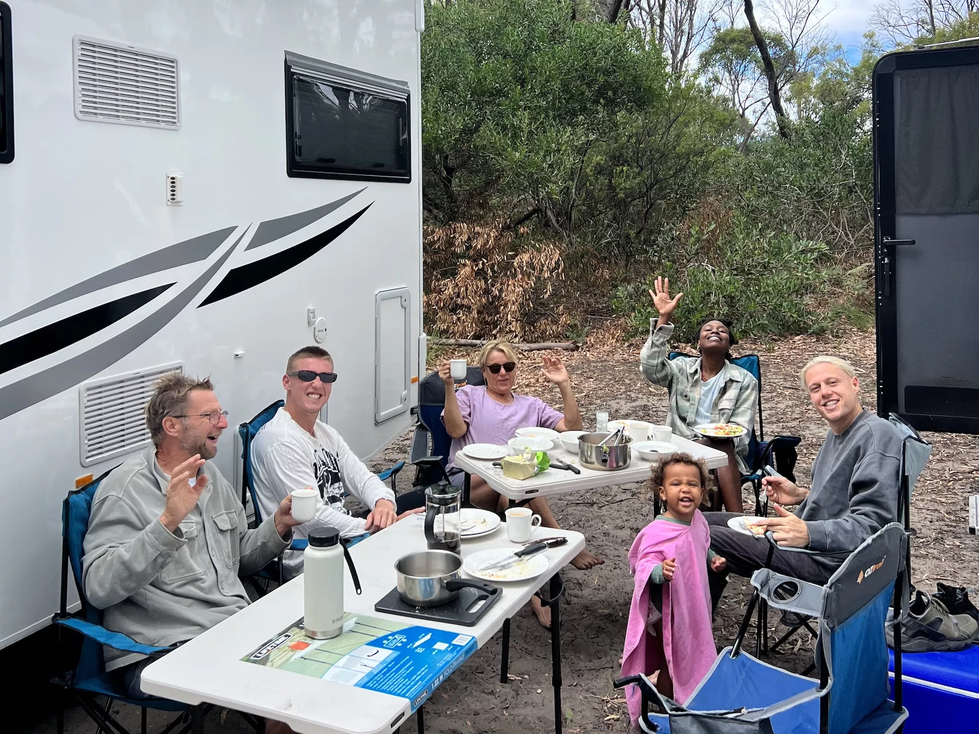 A family enjoying their meal by a campervan