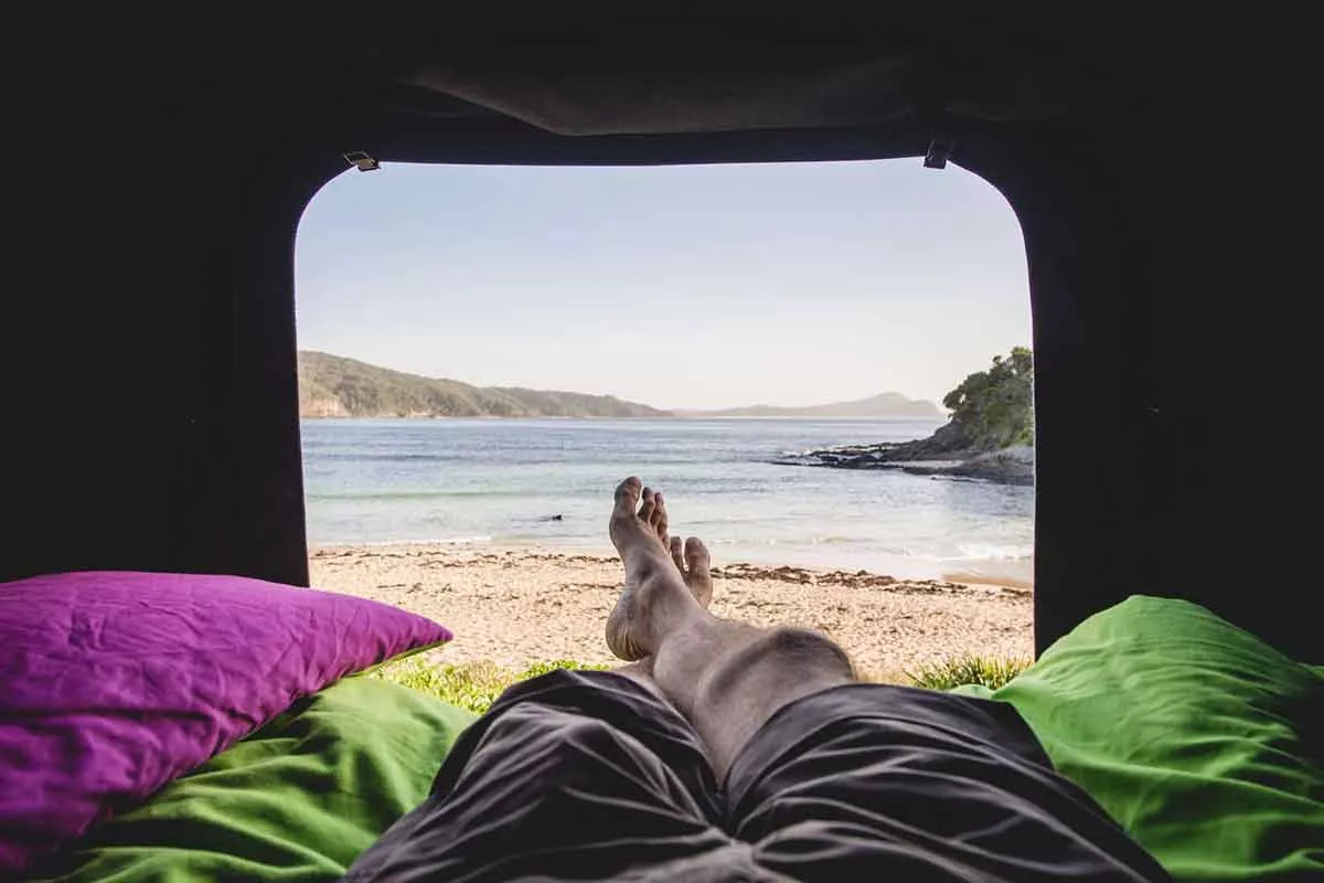 A view of the beach from inside a camper
