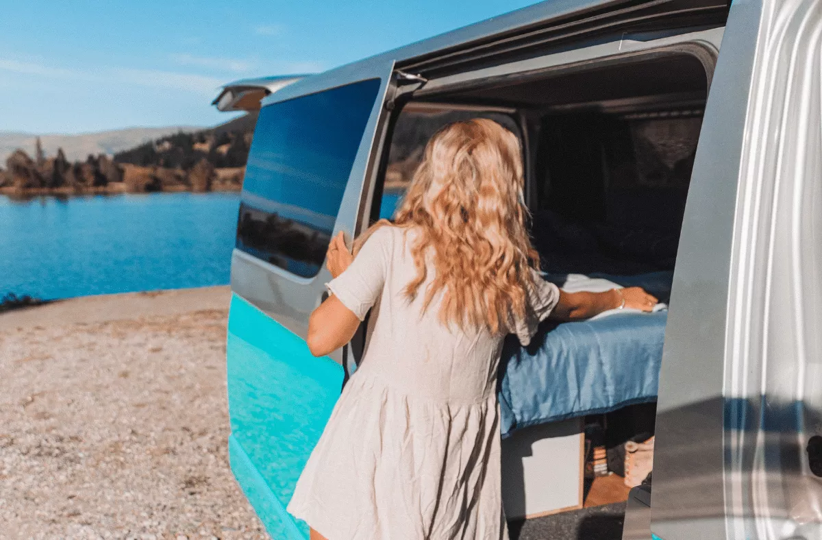 Sun-soaked morning vibes as a RatPacker opens the camper back doors overlooking a dreamy lake in New ZealandSun-soaked morning vibes as a RatPacker opens the camper back doors overlooking a dreamy lake in New Zealand
