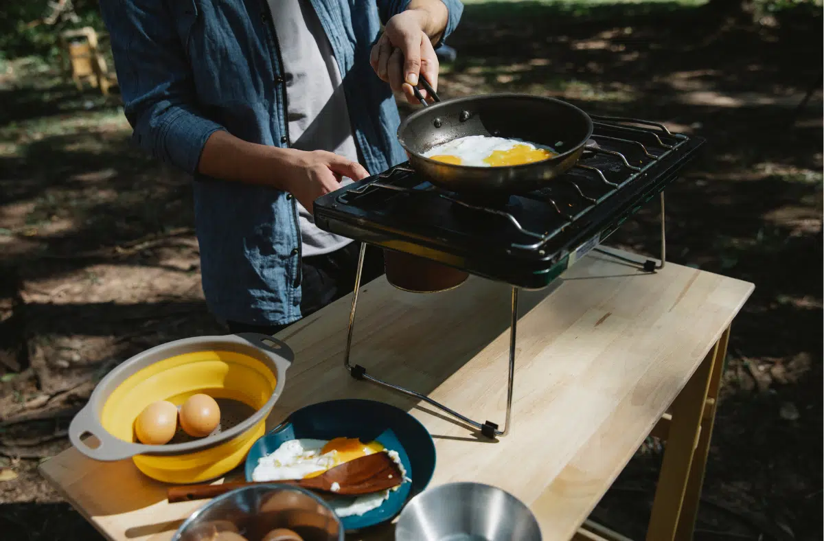 man frying eggs in camping