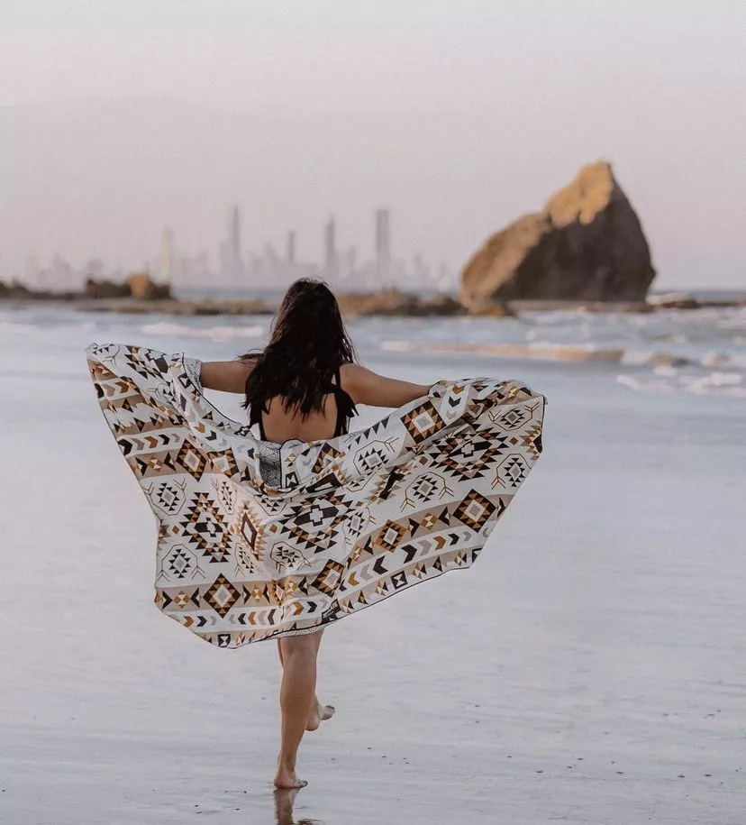 Woman on the beach in front of Melbourne's skyline
